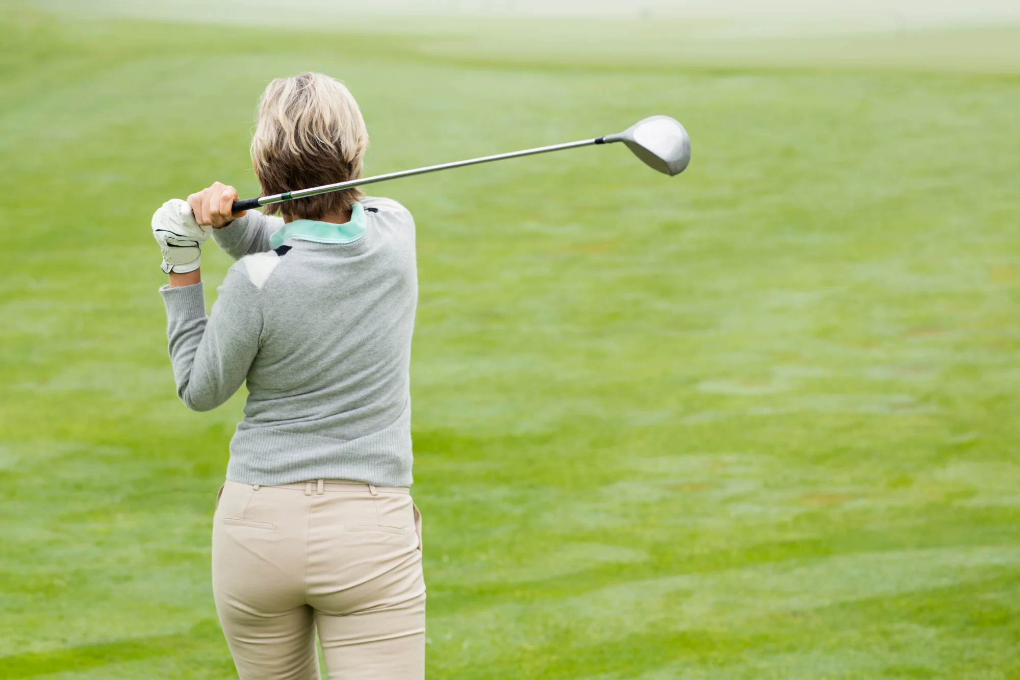 Women golfing with golfer's elbow
